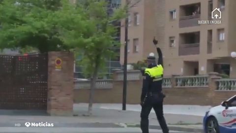Un policía de Zaragoza se arrodilla ante los balcones y deja flores por las víctimas del coronavirus